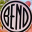 The emblem on A white circular vinyl sticker held in a hand, outdoors, Carstickers.com, March 5, 2021.
