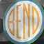 The emblem on The storefront sign, beside a solar-panel announcement, The Bend Store, February 16, 2023.