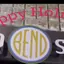 The emblem on The storefront sign at night, the disc in orange, The Bend Store, November 22, 2023.