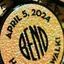 The emblem on Art Walk buttons, each carrying the disc inside a “Happy Art Walk” ring, The Bend Store, April 5, 2024.
