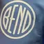 The emblem on Two children in coral and blue hoodies carrying white discs, The Bend Store, June 27, 2024.