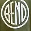 The emblem on A child in an olive hoodie with a white disc, a metal disc sculpture on the wall behind, The Bend Store, September 21, 2024.