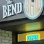 The emblem on The storefront at dusk, the disc sign in orange, The Bend Store, November 30, 2024.