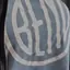 The emblem on Grey tee with a large white disc, a bag strap across its edge, The Bend Store, July 4, 2025.