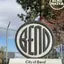 The emblem on The entrance-sign disc, above a stone base reading City of Bend / Utility Department / OUTBACK WATER FACILITY, City of Bend, July 15, 2026.