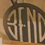 The emblem on Discs on a shelf, a cap with a disc patch, and a wooden ornament, The Bend Store, July 27, 2026.