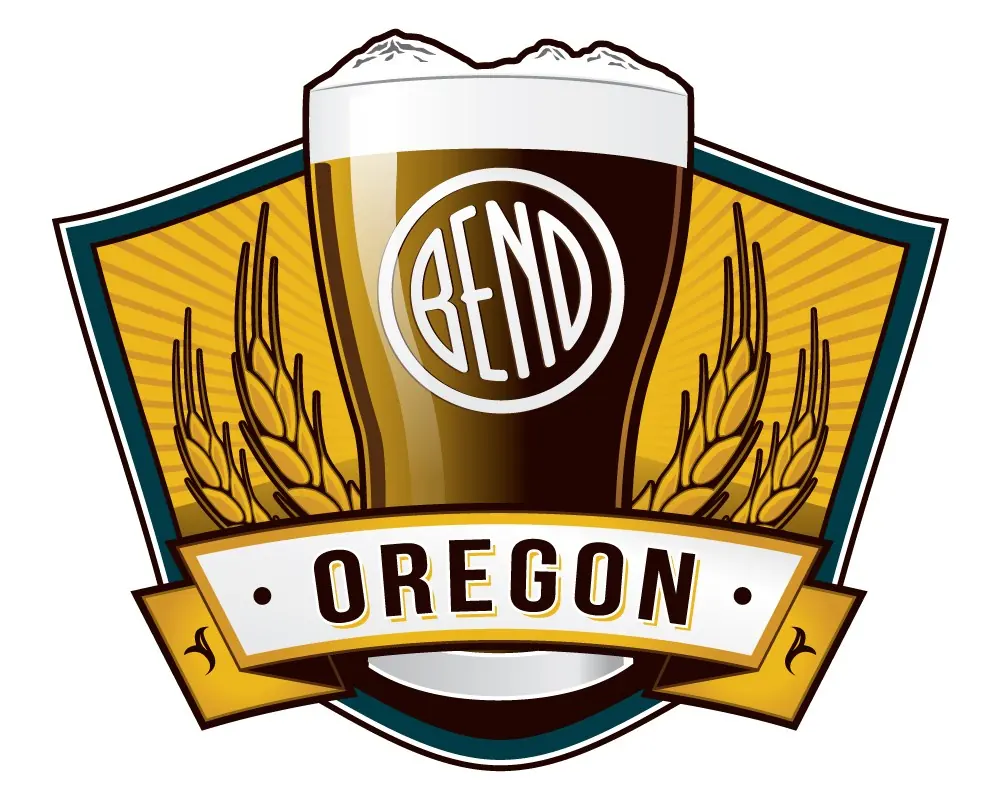 A pint glass topped by the Three Sisters, with a tilted white Bend emblem, barley and an Oregon banner.