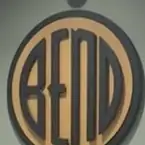 A large wooden disc on a wall, the word BEND cut into its tan face inside a dark ring.