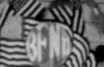 A circular banner carrying the word BEND, set in striped bunting with flags on either side, high on a wooden wall.
