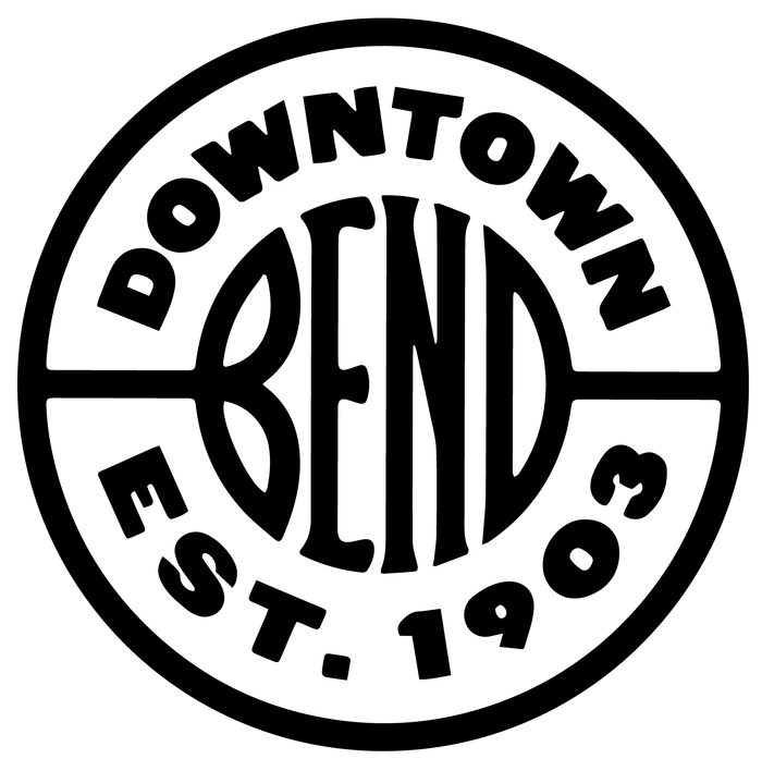 A circular badge with the letters BEND at its centre, drawn in black on white, with lettering curved around the ring.