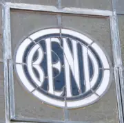 White BEND letters within a circular border, set in a stained-glass transom and its weathered frame.