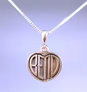A heart-shaped silver Bend pendant with narrow letters, an arched n and a sunstone above it.